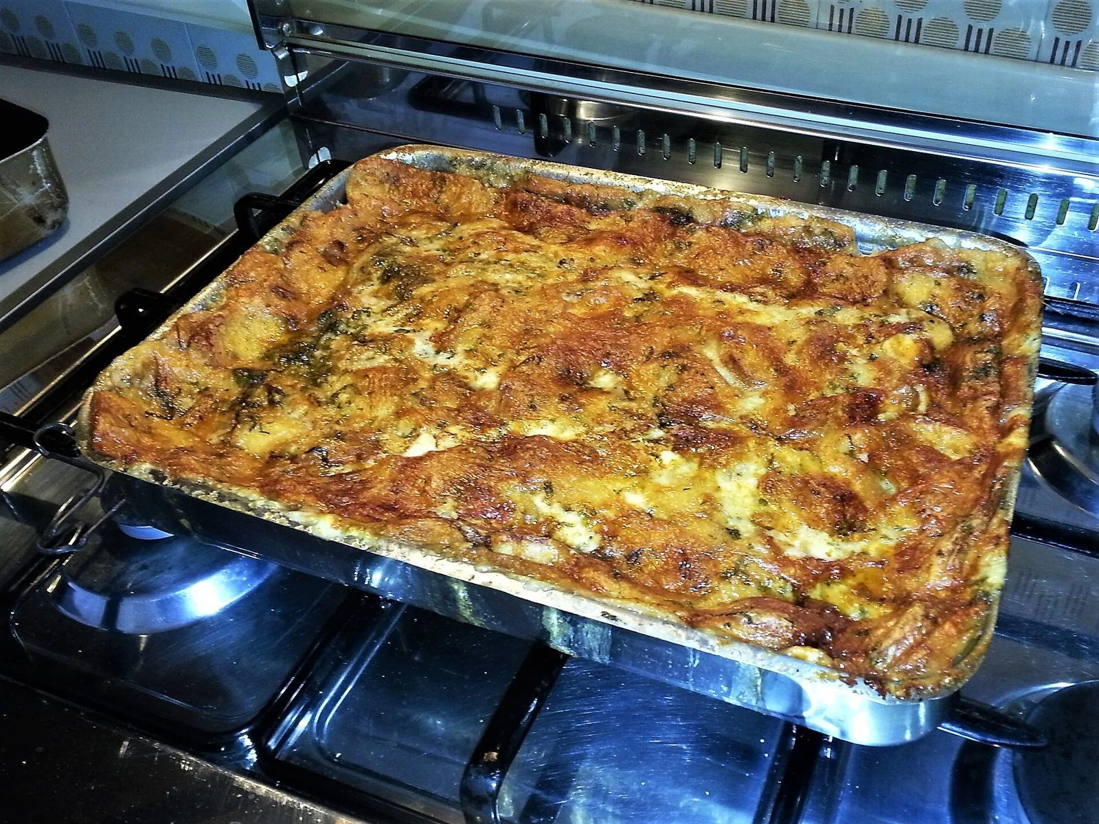 Teglia di zuppa gallurese appena sfornata, con la crosta di formaggio dorata