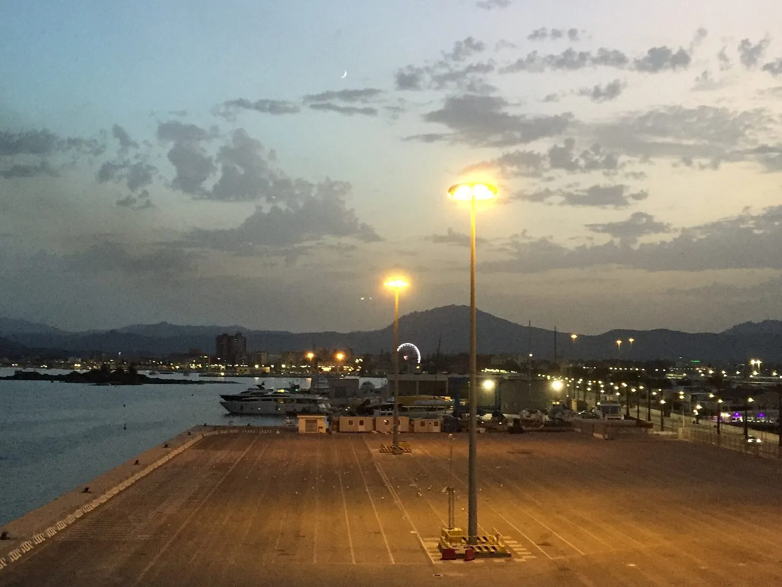 Il porto di Olbia Isola Bianca al tramonto, con le luci della città e le colline della Gallura sullo sfondo